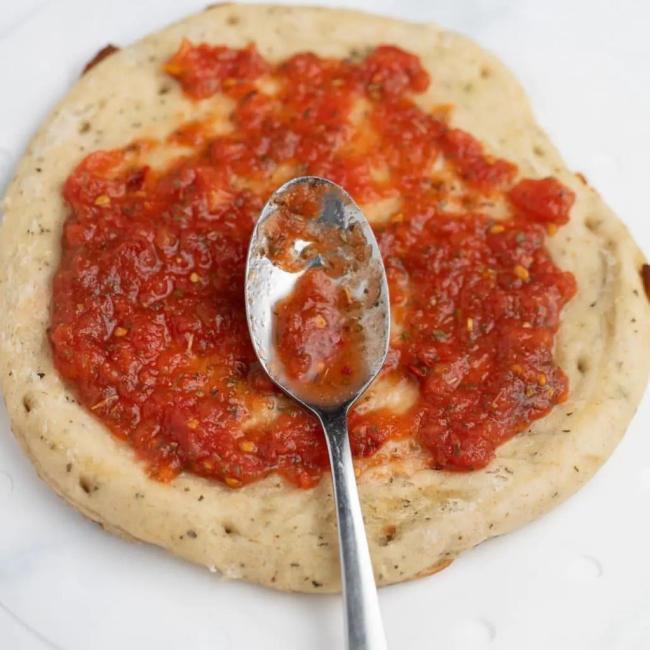 Phết sốt cà chua lên đế bánh pizza